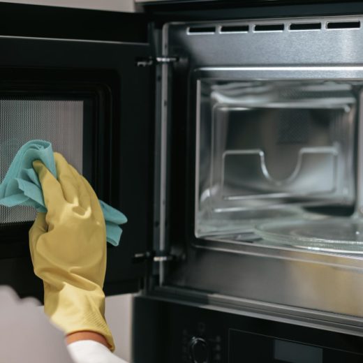 woman-yellow-gloves-cleaning-oven